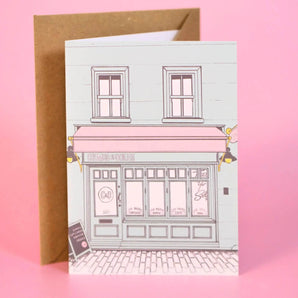 Crumbs & Doilies Greetings Card featuring a cute Soho shop illustration, blank inside for a personal message.